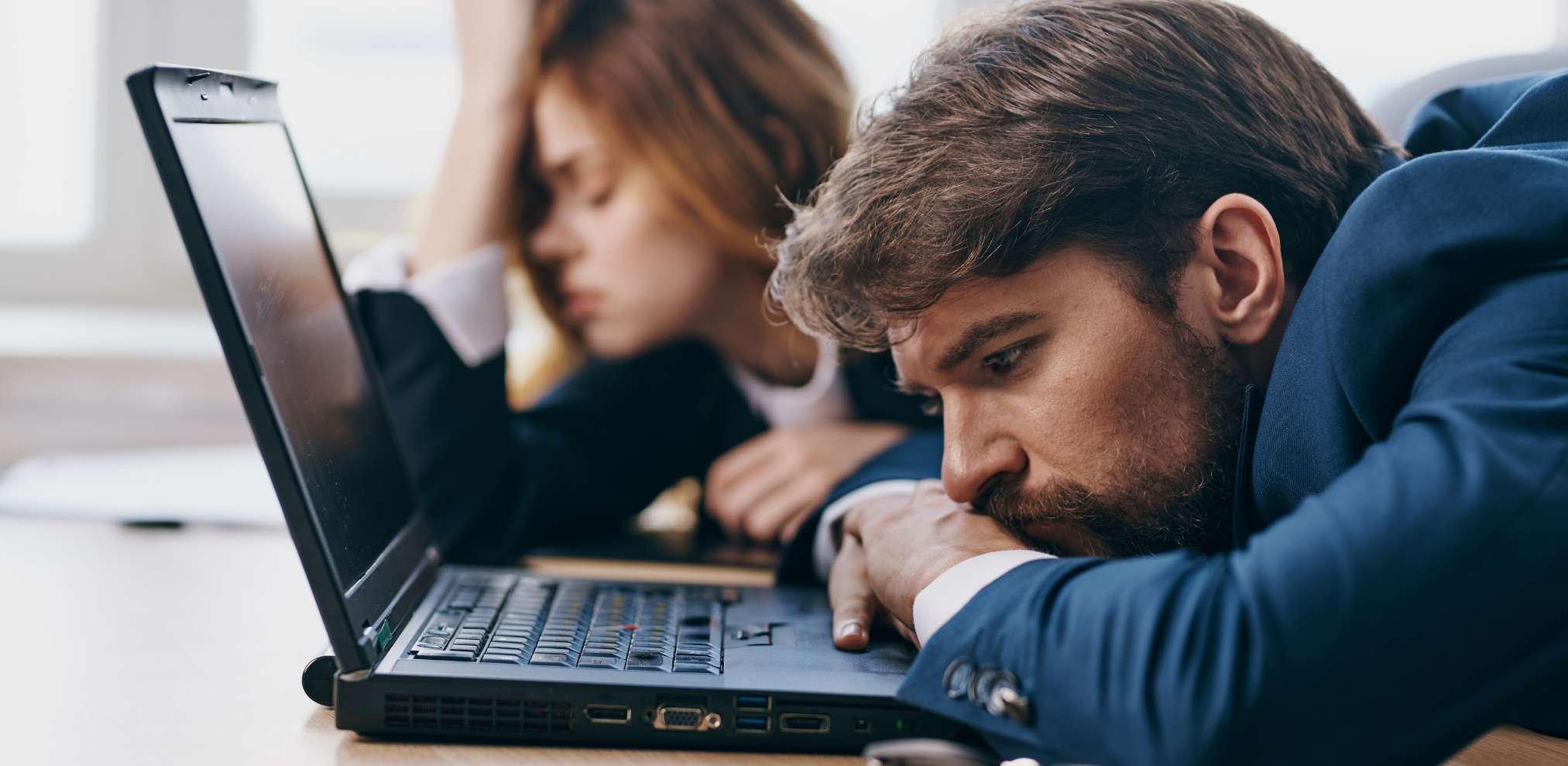 Müde Mitarbeiter vor dem Laptop